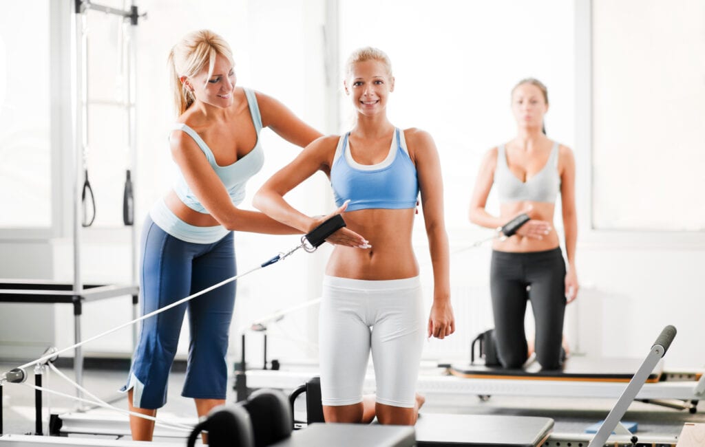 Pilates teacher helping her student