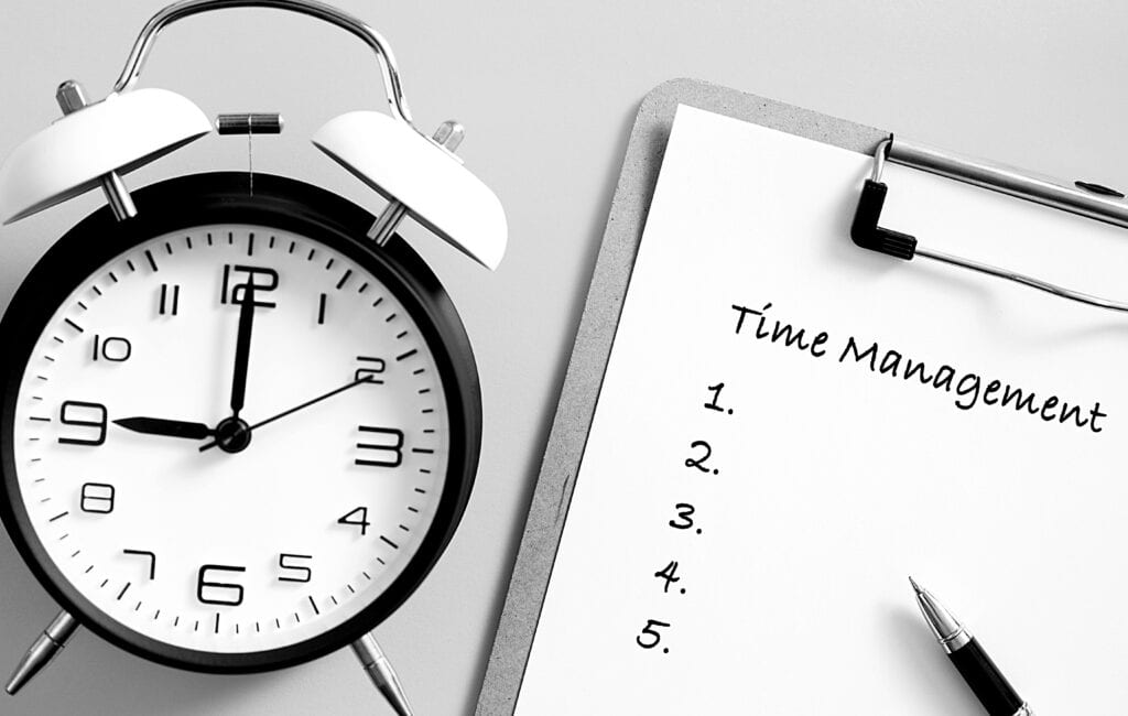 alarm clock and clipboard with time management check list written