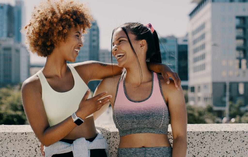 Multiracial Pilates clients happy talking and laughing together after class