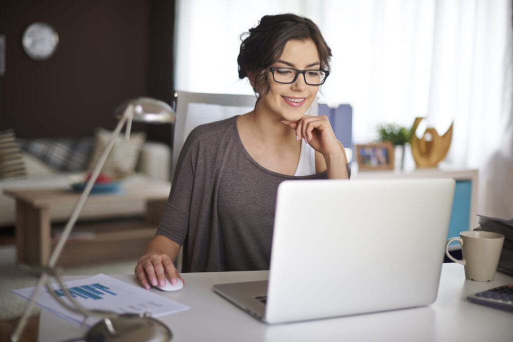 Woman smiling in home office working on computer