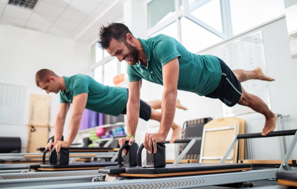 Men doing the Pilates exercise on the Reformer